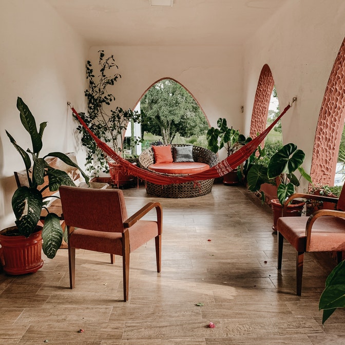 área de descanso con sillones y hamacas con vista al jardín.